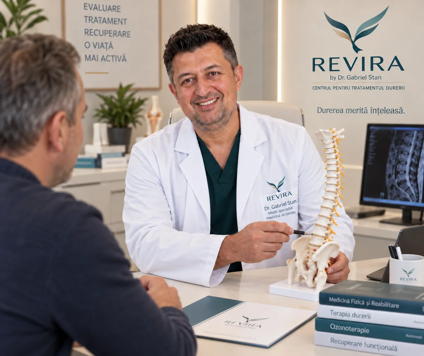 Dr. Gabriel Stan discută la birou cu un adult și explică un model anatomic al coloanei.