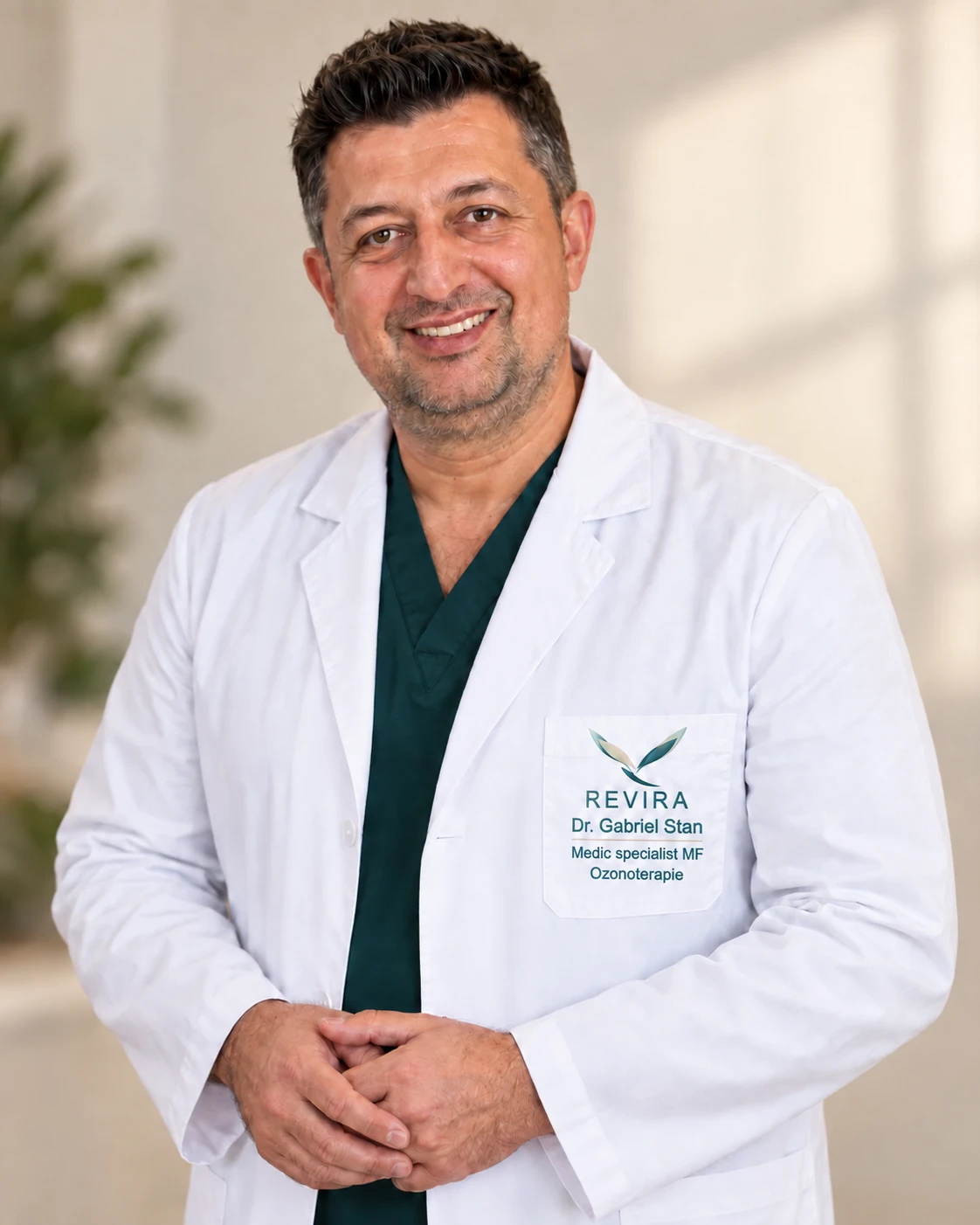 Dr. Gabriel Stan în halat alb, cu logo-ul REVIRA și inscripțiile Medic specialist MF și Ozonoterapie pe buzunar.